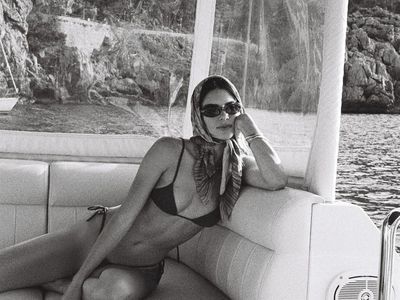 Kendall Jenner wearing bikini and scarf headwrap with sunglasses on a boat
