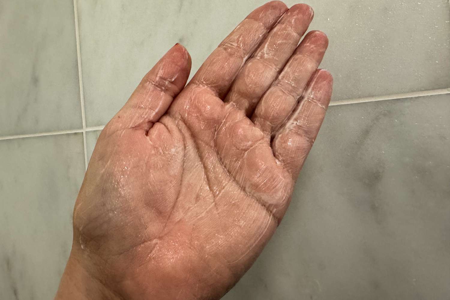 A person lathers fresh Milk Body Cleanser in their hand