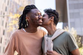 Two people hug and kiss on the cheek