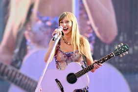 Taylor Swift stands on stage in a sparkly outfit holding a purple guitar