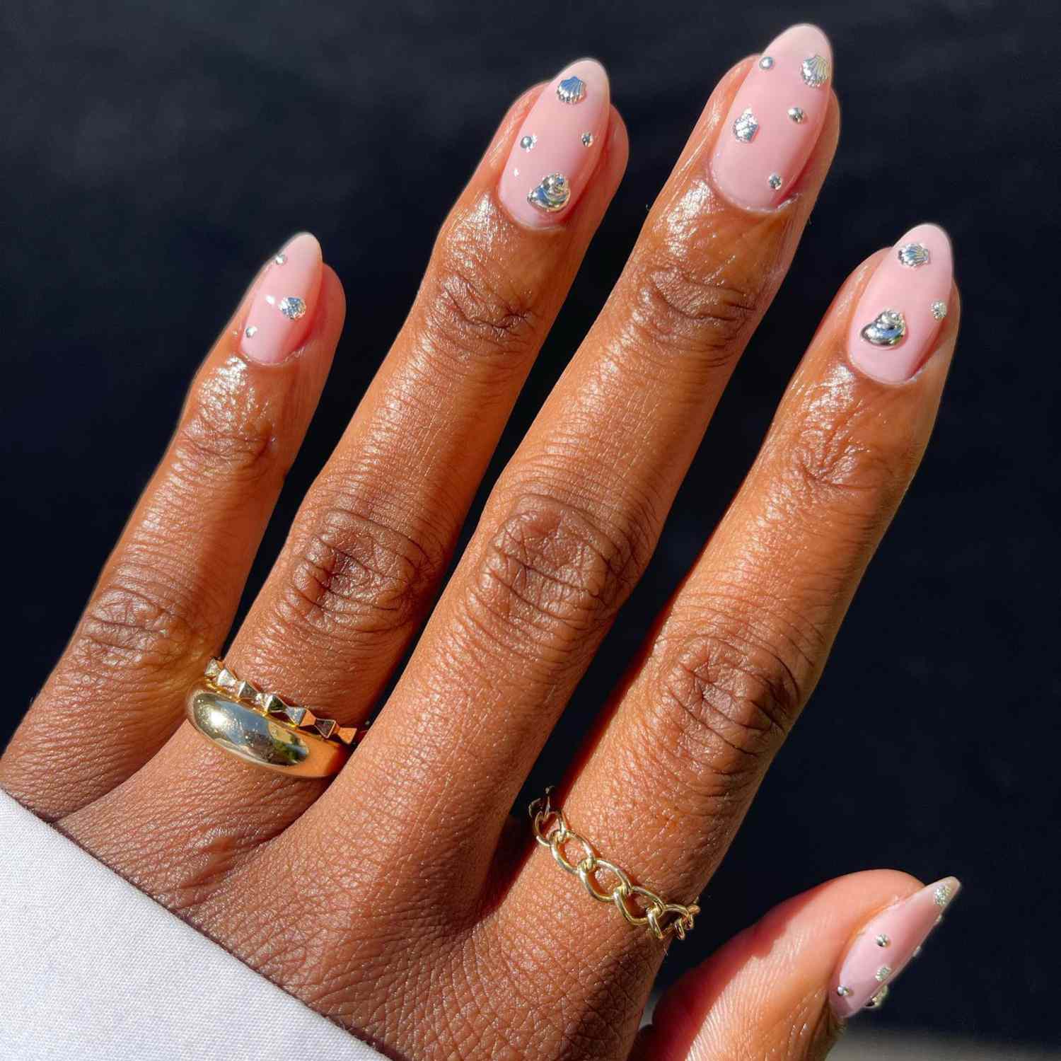 close up of nails with light pink manicure with rhinestones