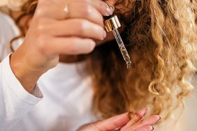 Woman Putting Hair Oil on Her Curly Hair