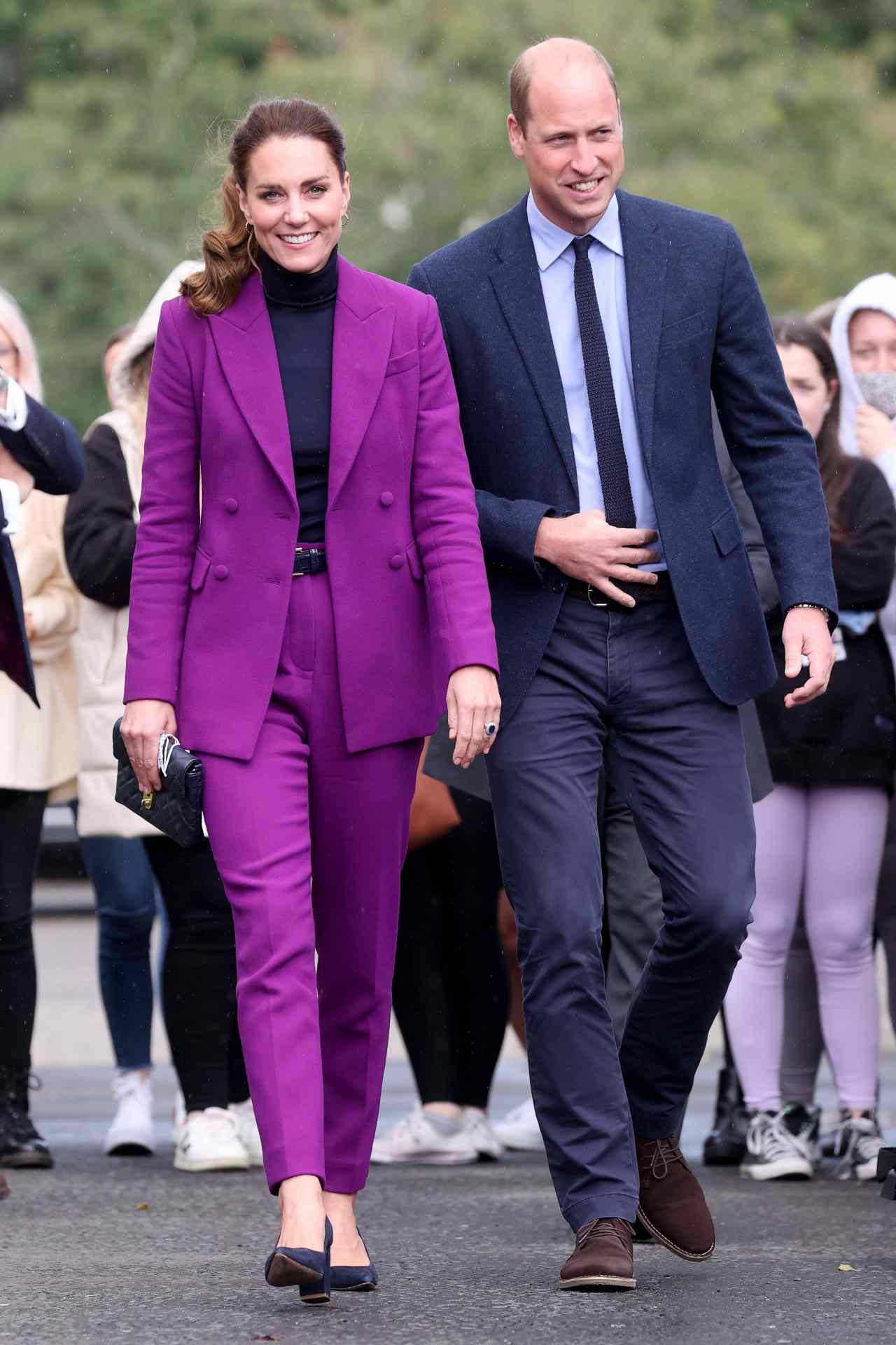 Kate Middleton in a bright purple suit alongside Prince William