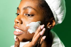 Black woman putting on skincare