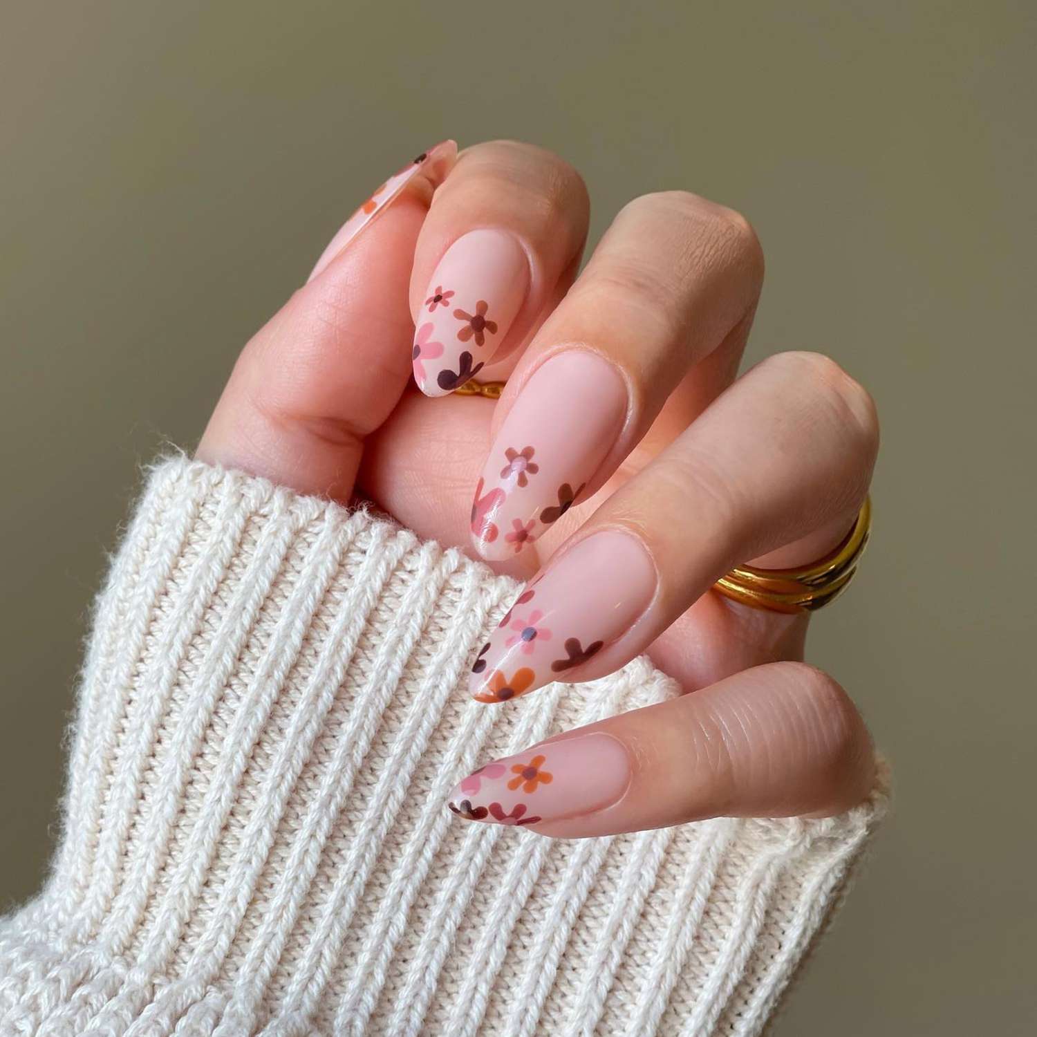 close up of nails with light pink base and flowers painted on tips