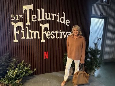 martha stewart in an orange sweater standing in front of the 51st Telluride Film Festival