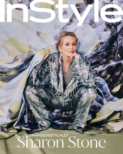 Sharon Stone InStyle February Cover crotching in front of green purple and black painting wearing a silver frayed suit