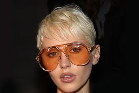 Miley Cyrus rocking a trendy blonde pixie cut.