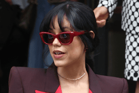 Jenna Ortega wears burgundy blazer and red sunglasses