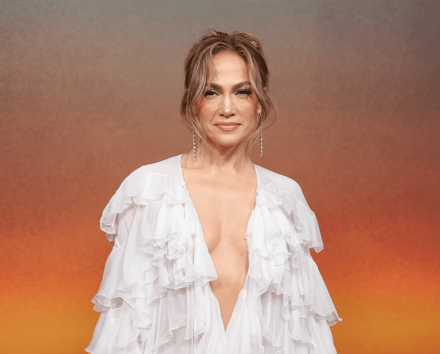 Jennifer Lopez photographed wearing a frilly white dress with a plunging neckline