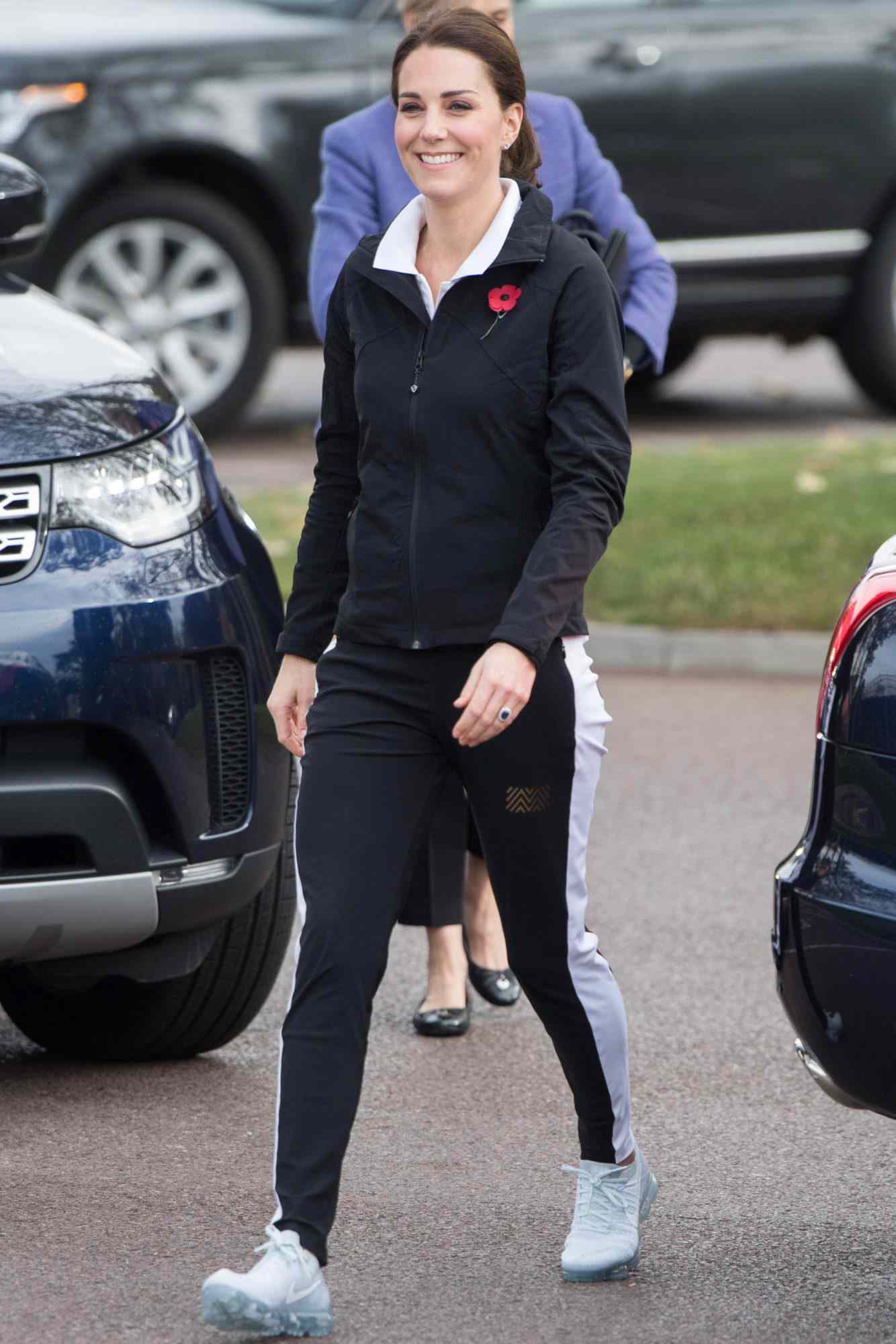 Middleton in a black zip-up, black and white track pants, and Nike sneakers