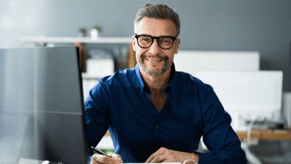 A man reviews financial documents, illustrating the difference between bookkeeping and accounting careers.