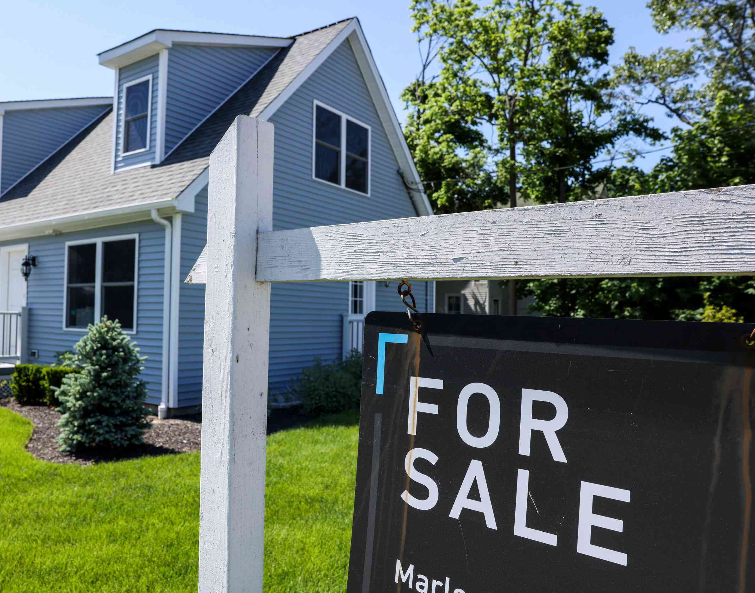 A "For Sale" sign in front of a house in Patchogue, N.Y.