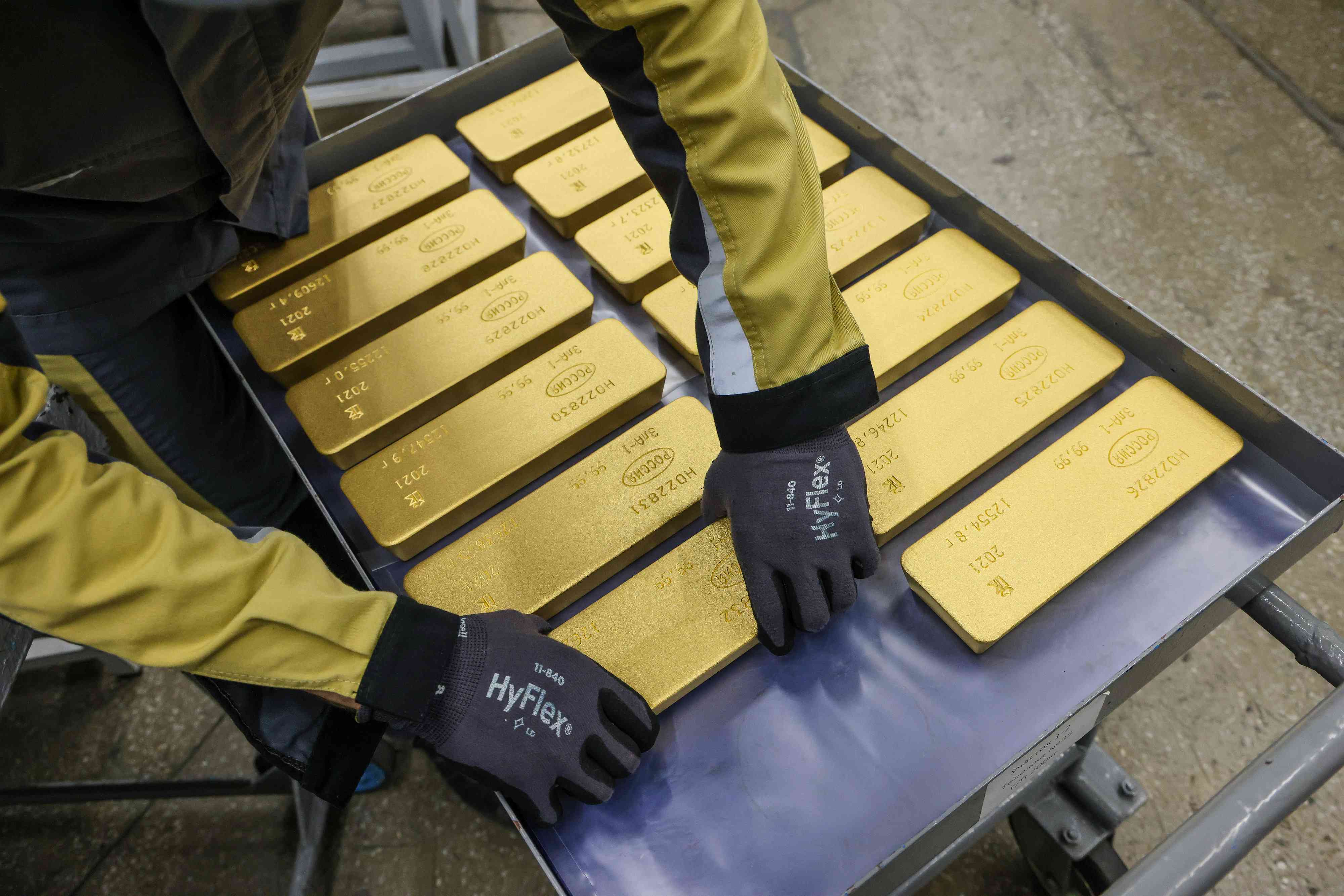 Worker loading gold bars onto a trolley
