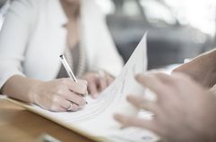 Signing Contract at Desk at Car Dealership