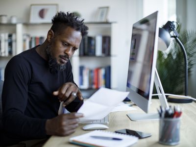 Man working with papers and a computer 