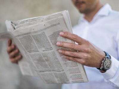 Close-up of businessman reading newspaper