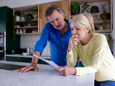 Couple reading a letter in their kitchen