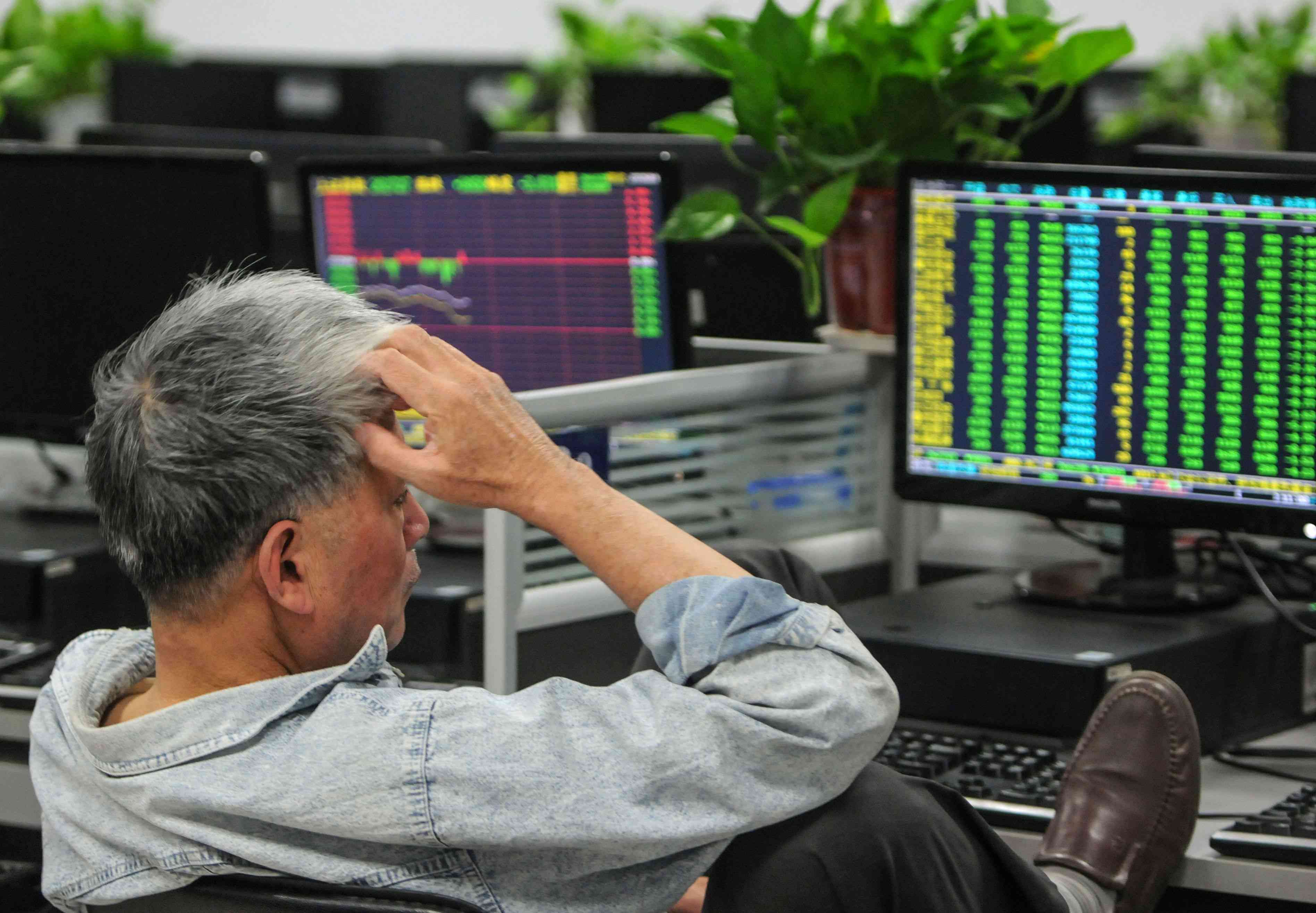 Investor looking with dismay at his positions on monitor