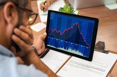 Man looking at declining stock position on his laptop