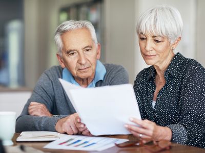 A couple going through their finances while sitting at the dining room table.