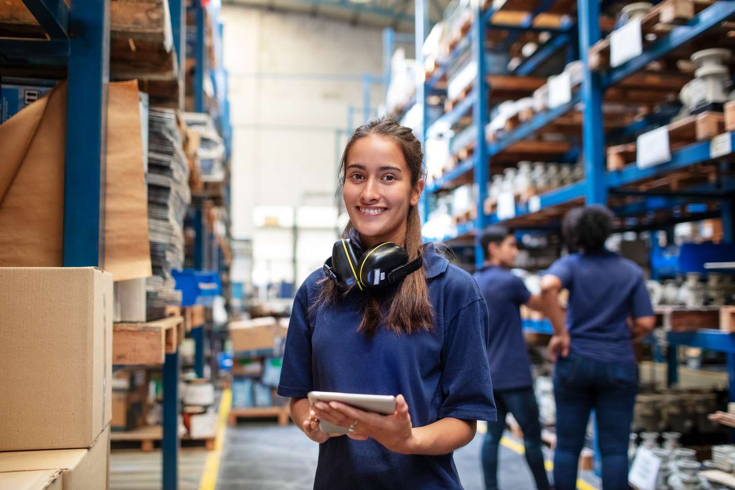 Smiling female warehouse worker holding a tablet