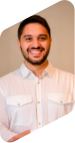 Retrato de Gabriel Salomão, homem de cabelo liso e curto e barba. Ambos na cor preta. Ele está sorrindo para a foto e usa camisa branca