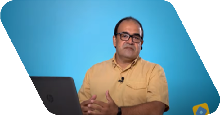 Short black hair man looking at camera. He wears a yellow shirt and is in front of a blue wall.