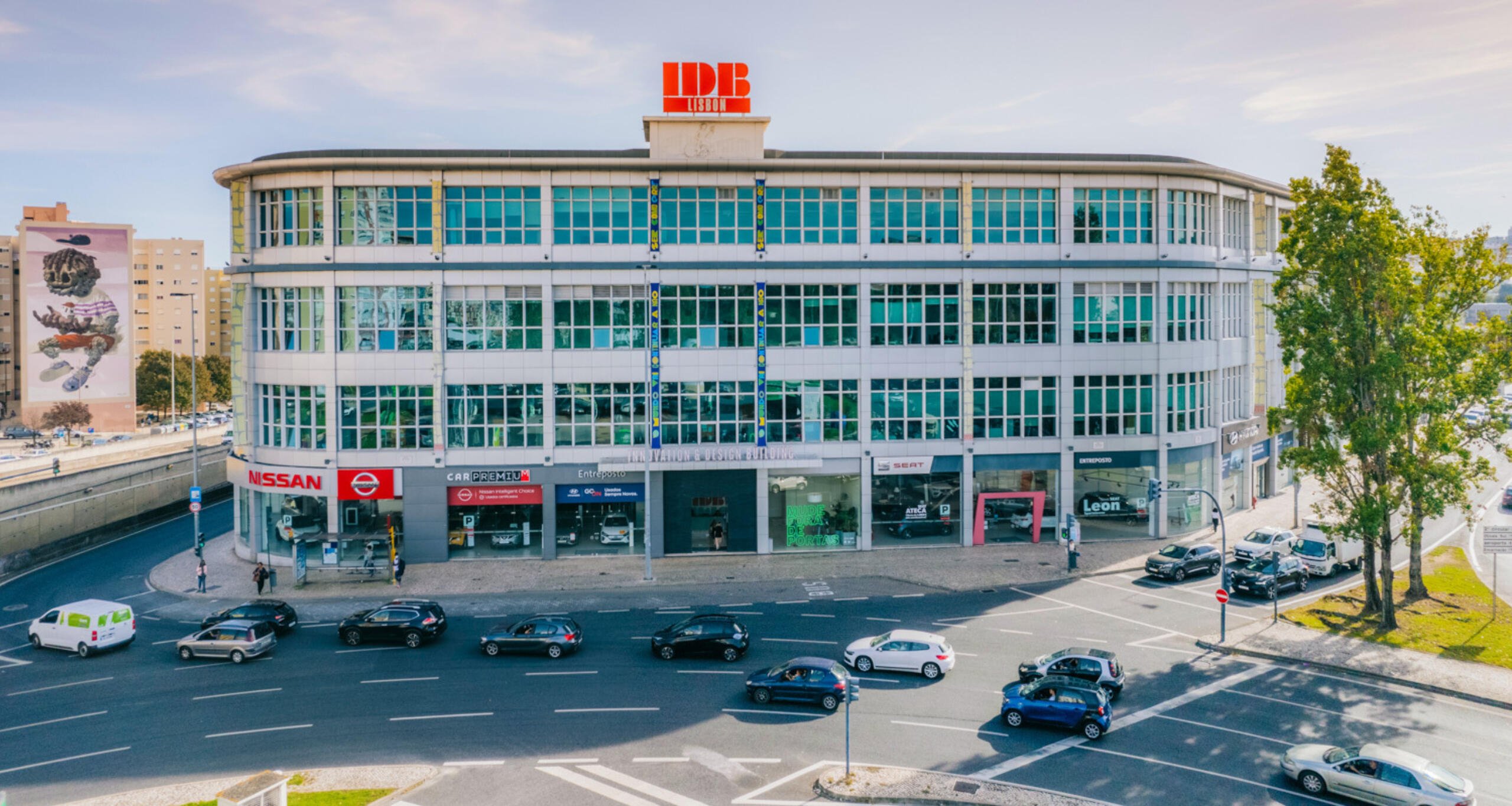 IDB Lisbon exterior façade with cars driving on street in foreground