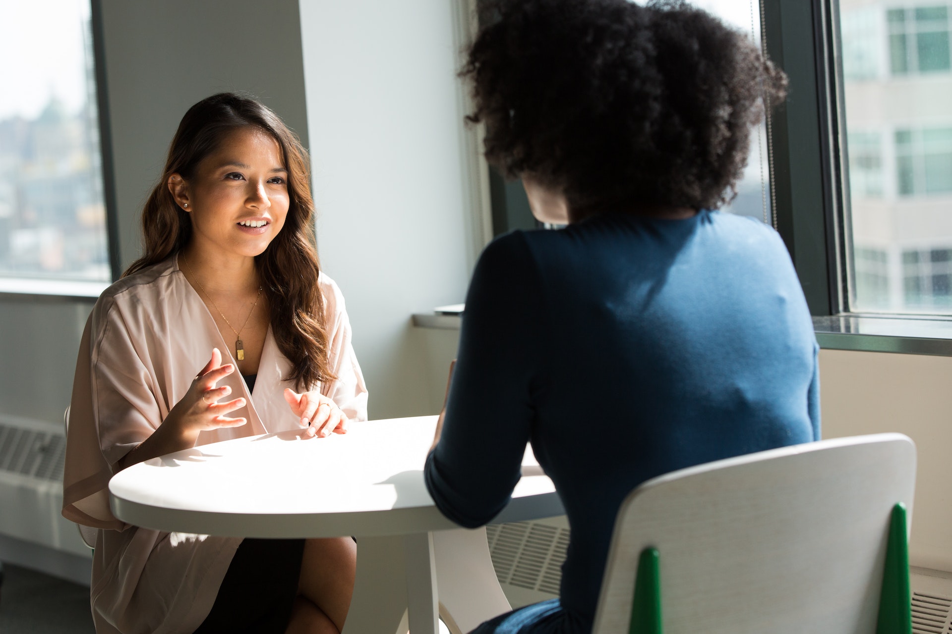 two women sitting at a table talking