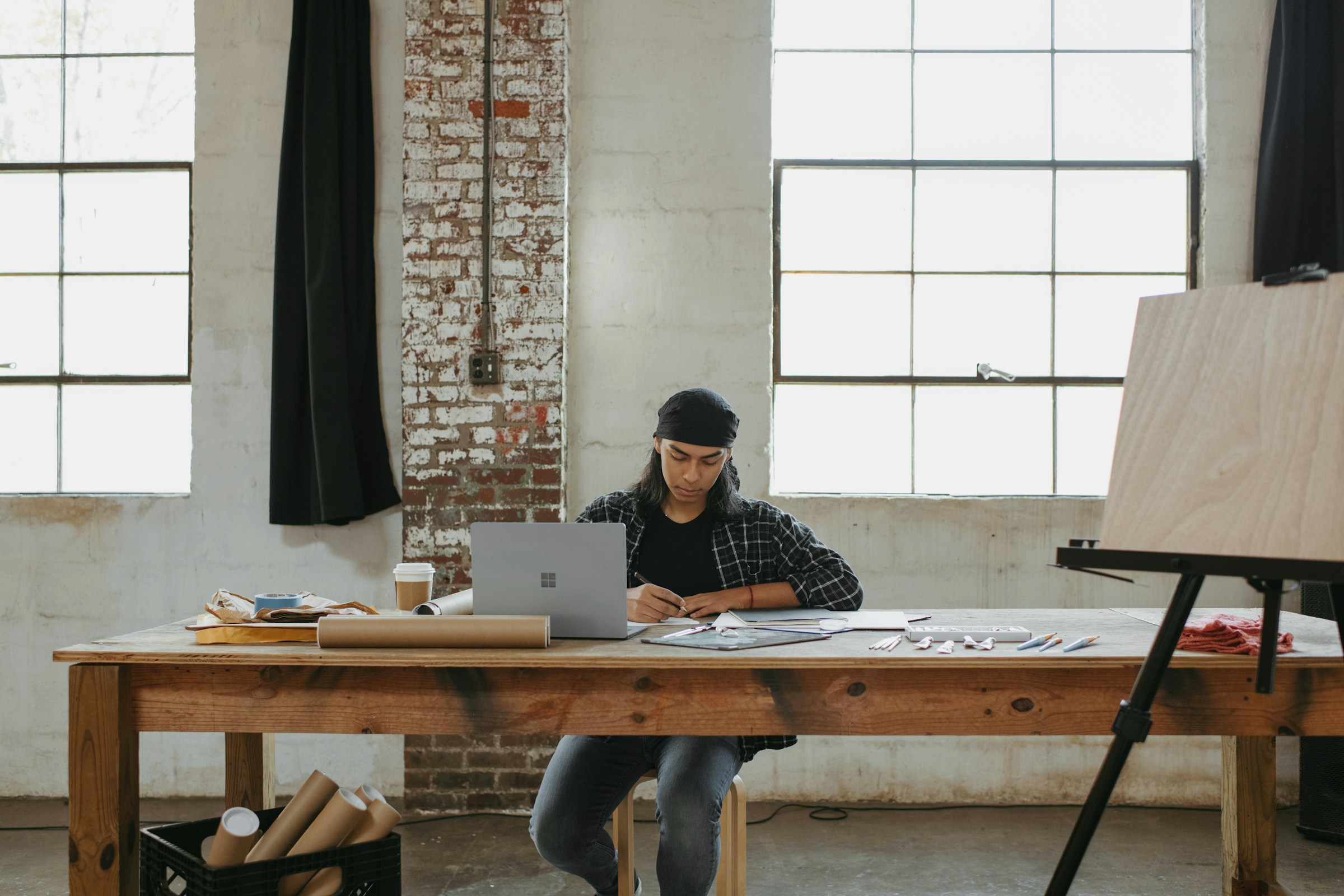 man sitting at a large table working artist designer