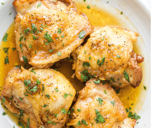 Juicy cooked chicken thighs on a plate.