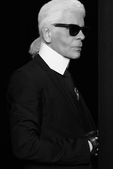 Karl Lagerfeld pictured wearing his iconic high-collared white shirt, sleek leather gloves and signature sunglasses.​