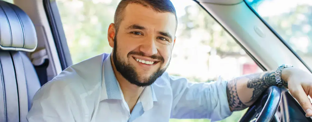 Homem sorridente ao volante