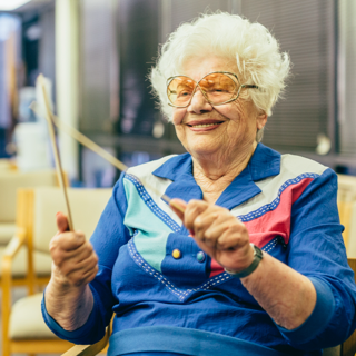 Woman smiling while holding drumsticks