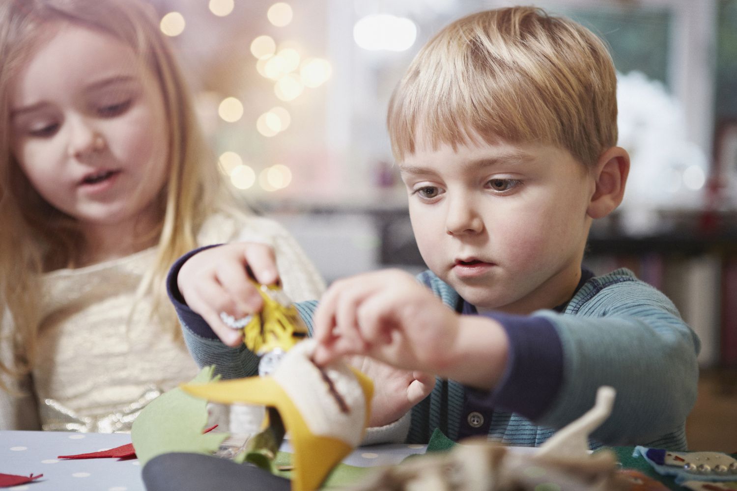 Young brother and sister crafting at kitchen table