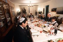 Jewish family praying before Seder dinner during Passover festival