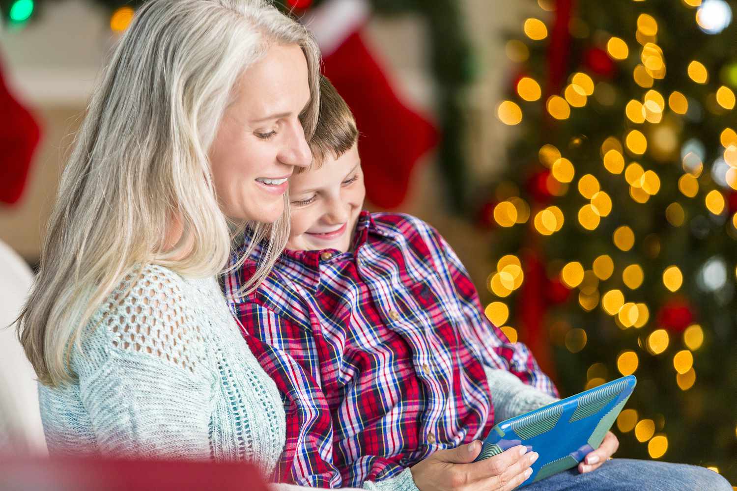 Grandmother reads story to grandson at Christmastime