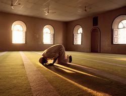 Muslim man praying in mosque.