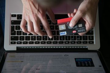 a woman uses a credit card to buy something online