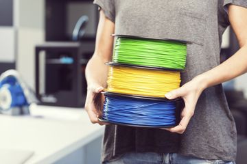 Computer technician carrying spools of filament