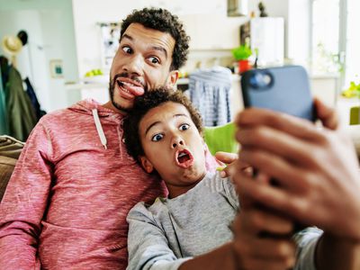 A father and son making funny faces while taking a selfie