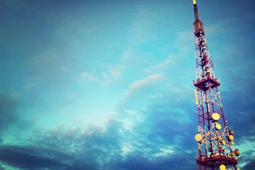 Radio transmitter tower against a partially cloudy blue sky