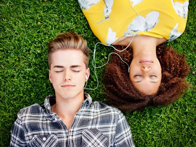 Young couple listening to and sharing music