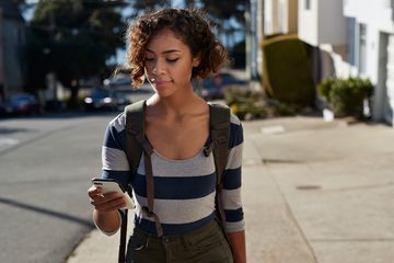 A woman using offline maps on her smartphone while traveling internationally.