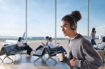 Someone in an airport wearing the Soundcore Space One Pro headphones.