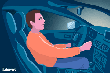 Image of a worried-looking person in a car without lights