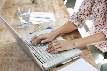 Woman using laptop at dining room table