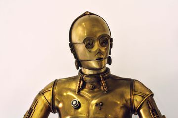 A torso t0 head view of the C3PO robot from the Star Wars movies.