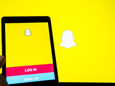 A hand holds a smart device while using SnapChat app